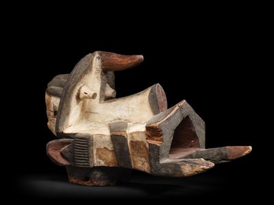 une photo d'une sculpture en bois représentant un bateau, munie d'une poignée en bois