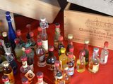 many bottles of liquor sitting on a red table cloth