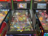 Plusieurs flippers sont alignés les uns à côté des autres dans une pièce