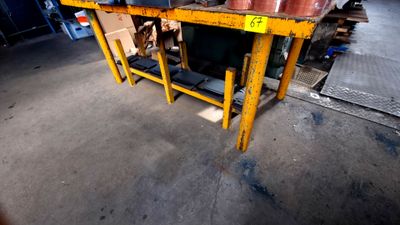 une table sur laquelle sont posés des casseroles et des poêles, dans un entrepôt