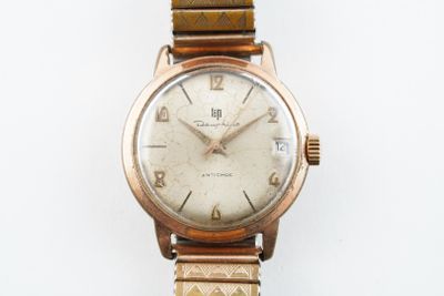 une montre-bracelet en or avec un cadran blanc sur fond blanc