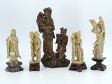 an image of a group of carved figurines sitting on top of a white surface