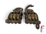 pair of antique brass pulleys on a white background