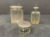three small glass jars with lids and lids on a table