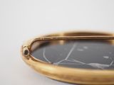 a close up of a gold plate with a mirror on it
