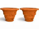 deux pots en argile posés l'un à côté de l'autre sur une surface blanche