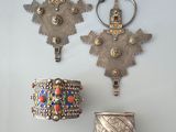 trois pièces d'argent sont accrochées au mur, à côté d'un vase