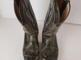 a pair of black cowboy boots on a white surface