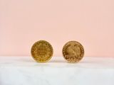 a pair of gold coins sitting on top of a marble counter