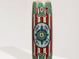 une image représentant un vase coloré posé sur une surface blanche