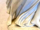 a statue of a woman sitting on top of a table