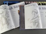 three books on a table with a drawing of a man and a woman