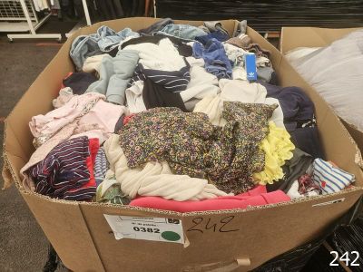 a cardboard box full of clothes on display in a store