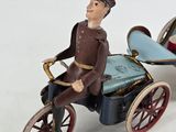 toy figurine of a man riding a horse drawn carriage