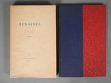 an old book sitting on top of a table next to a red and blue book