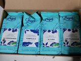 quatre paquets de café sont posés dans une boîte en carton sur une table