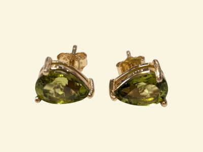 a pair of yellow gold earrings with peridot stones
