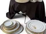 many plates and cups on a table with a black table cloth