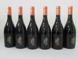 six bottles of wine are lined up on a white surface