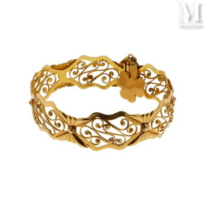 gros plan d'un bracelet en or sur fond blanc