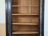 a tall wooden bookcase with many shelves in it
