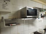 a microwave that is sitting on a shelf above a sink