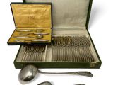 a green case with silverware in it on a white surface