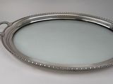 a silver tray with a mirror on it on a table