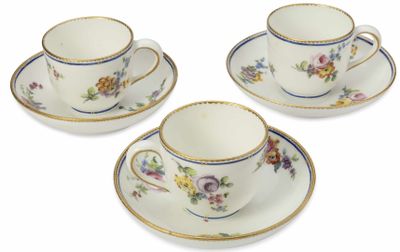 trois tasses et soucoupes ornées de motifs floraux sur un fond blanc