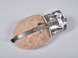 a small silver object on a rock with a knife in it