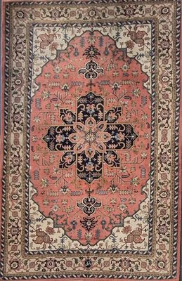 an antique persian rug with a medallion design on a pink ground
