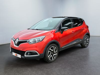 Une voiture rouge est garée dans une pièce blanche au sol noir.