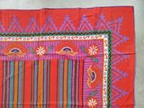 an image of a red table cloth with colorful designs on it