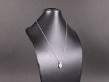 a close up of a necklace on a mannequin with a black background