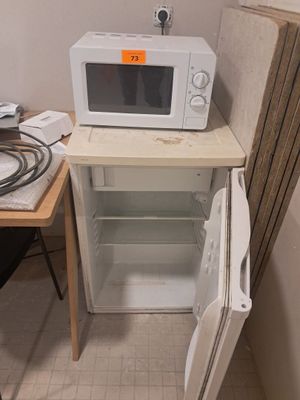 a white microwave sitting on top of a small cabinet