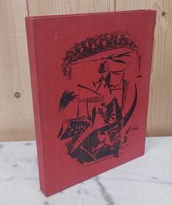 Le livre rouge est posé sur une surface en marbre, avec un mur en bois en arrière-plan.