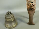 a bell and a statue of a pig on a table