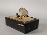 a coin sitting on top of a box with a coin in it