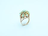 a close up of a gold ring with turquoise stones on it