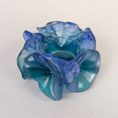 une fleur en verre bleu posée sur une table