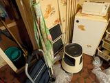 une photo d'une chambre en désordre avec un réfrigérateur, un micro-ondes et d'autres objets