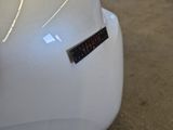 the back end of a white motorcycle with a sticker on it