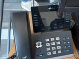 a desk with a phone and a monitor on it