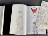 three books that are open on a table