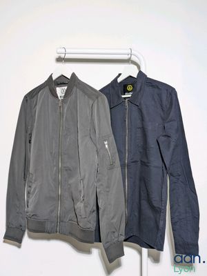 an image of two jackets hanging on a hanger in a room