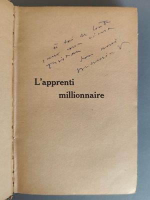 un livre ouvert, sur lequel figurent des inscriptions, posé sur une surface bleue