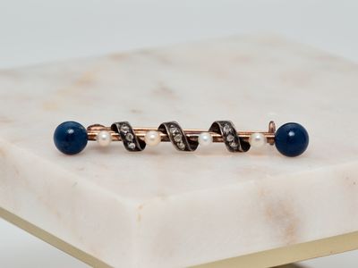 un gros plan sur une paire de boutons de manchette posés sur une surface en marbre