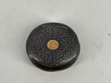 an image of a black and gold box with a flower design on it