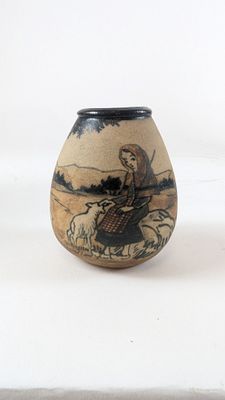 a small vase with a painting on it on a white surface