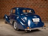 a blue car that is parked in front of a brick wall